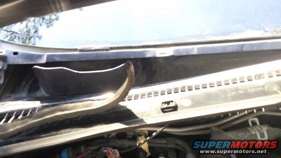 Underside of windshield cowl with some plastic trim detached and visible wiring