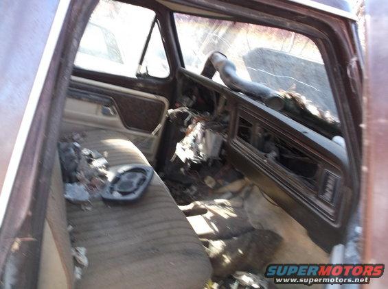 Interior of a brown truck with damaged dashboard and seats