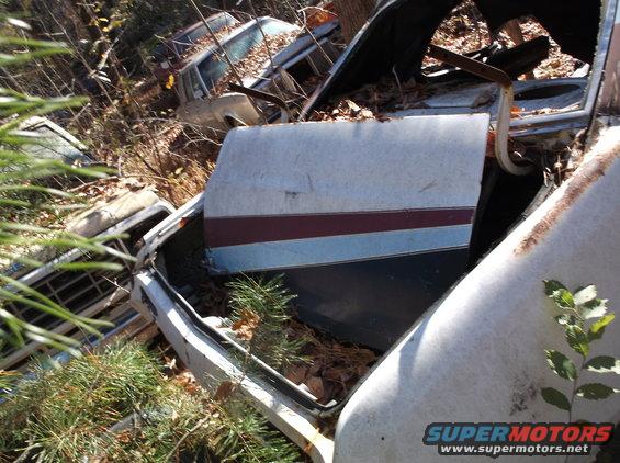 Junkyard car interior with two-tone door panel and visible SUPERMOTORS watermark