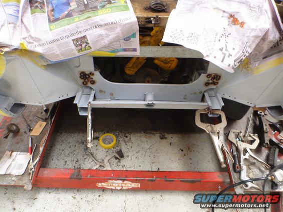 car chassis on lift, covered with newspaper, with tools nearby