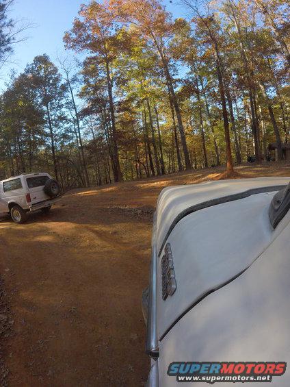 White SUV with spare tire on rear door, seen from the front passenger side
