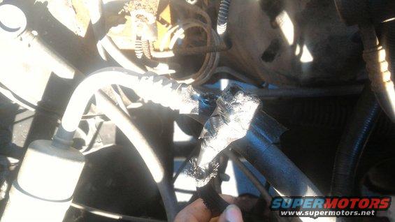 Engine bay showing a damaged hose wrapped in tape