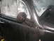 1964 Volkswagen Beetle - The side mirror and door of a black Volkswagen Beetle are shown, covered in water droplets.