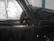 1964 Volkswagen Beetle - Close-up of a black 1964 Volkswagen Beetle's door and side mirror, showing water droplets on the wet surface.