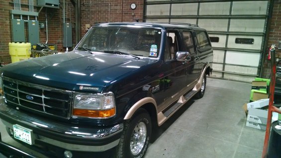 Dark blue Centurion conversion van with tan trim, parked inside a garage