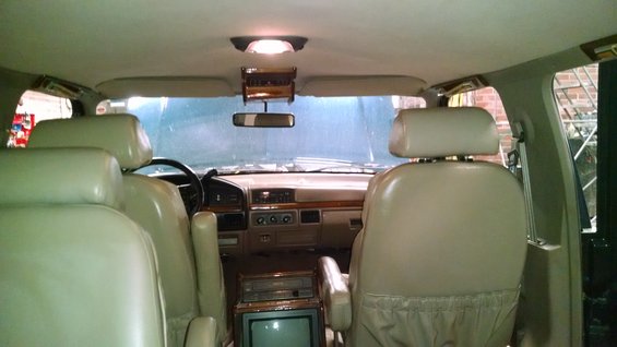 Interior view of a 1995 Ford C-150 Centurion Conversion van, showing front seats, dashboard, and rear seating area