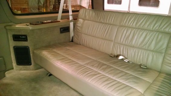 Interior with beige leather bench seat and console with vents