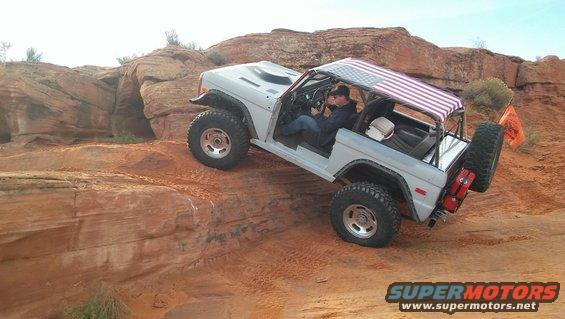 White 1979 Ford Bronco with American flag roof on rocky terrain