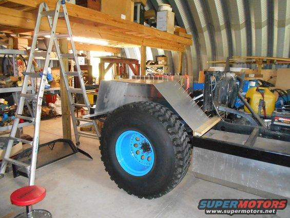 Custom off-road vehicle chassis with large tire and blue wheel
