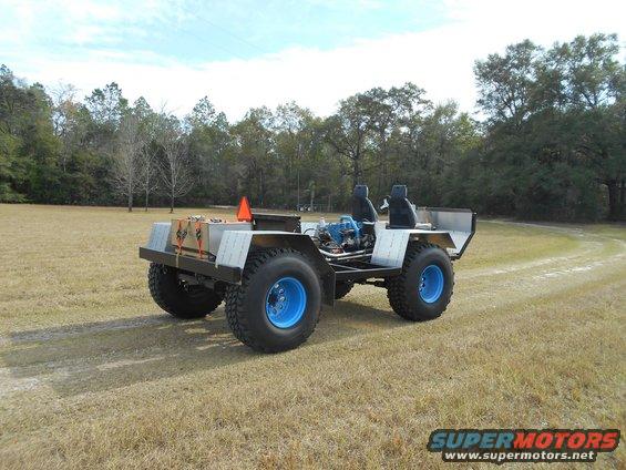 Custom all-terrain vehicle with blue wheels and exposed engine, seen from 3/4 front