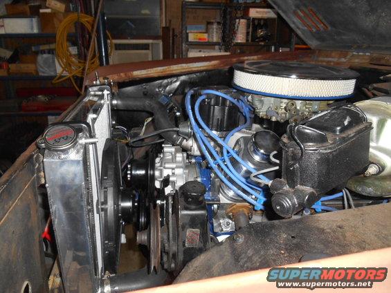 Engine bay showing a V8 engine, aftermarket radiator, and air filter