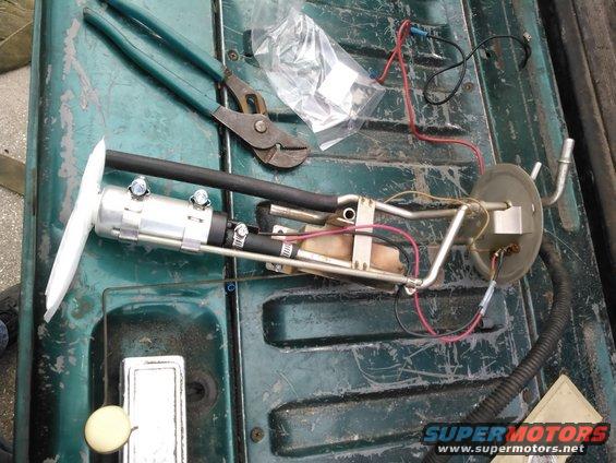 Fuel pump assembly with filter sock and pliers on a green truck bed