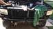 1995 Ford Bronco - Front view of a green Ford Bronco with the hood open, revealing the engine and radiator assembly.