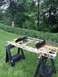 1995 Ford Bronco - This radiator support assembly is shown on sawhorses in a grassy yard, with trees and bushes in the background.