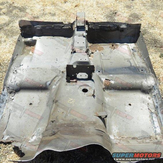 Corroded car floor pan, viewed from above, showing rust and damage