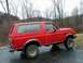 1990 Ford Bronco - Side view of a red 1990 Ford Bronco parked outdoors.