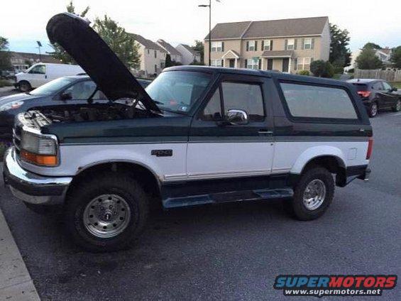 1995 Ford Bronco with hood open, parked on asphalt