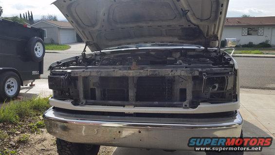 Ford F-Series truck with hood open, grille removed, and headlights out