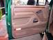1996 Ford Bronco - Interior view of a 1996 Ford Bronco's driver's side door panel, tan upholstery and wood accents.