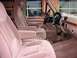 1996 Ford Bronco - The interior of a truck shows plush front seats and a wood-trimmed dashboard.