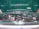 1996 Ford Bronco - The engine bay of a green vehicle is shown with the hood open, revealing the engine and various components.
