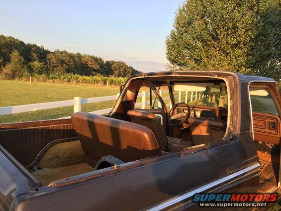 Brown 1978 Ford Bronco interior with removed roof, seen from the rear passenger side