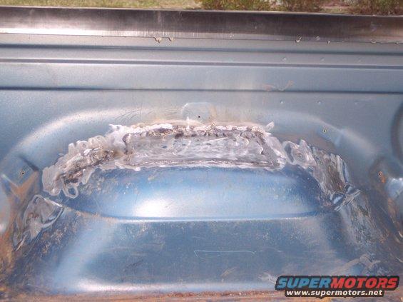 Welded patch on blue metal interior of a vehicle bed