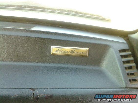 Gold Eddie Bauer emblem on dark dashboard of a 1991 Ford Bronco