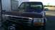 1996 Ford Bronco - The front of a dark red 1992 Ford Bronco is visible, a chrome grille and an aftermarket winch mounted on the front bumper.