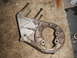 1990 Ford Bronco - A metal engine bracket with bolts is shown on a carpeted floor.