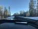 1991 Ford Bronco - Driving through a snowy forest landscape on a clear day, with other vehicles on the road ahead.