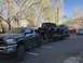 1991 Ford Bronco - A Ford F-350 Super Duty tows a trailer carrying a Jeep Wrangler and a Ford Bronco, with another white truck parked nearby.