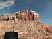 1991 Ford Bronco - View from a vehicle's side mirror shows a large, layered rock formation under a clear blue sky.
