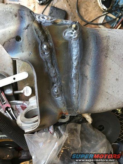 Close-up of a metal component with visible welds and some discoloration from heat