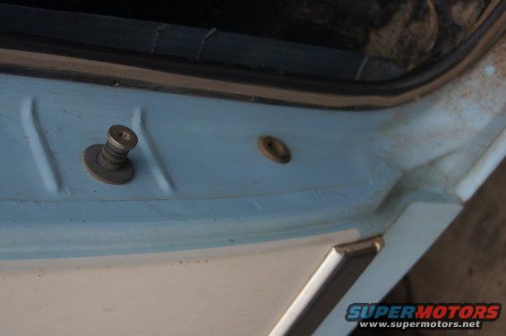 Door latch mechanism on a light blue and white vehicle interior, close-up