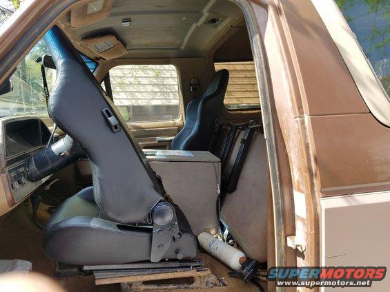 Interior view of a brown SUV with seats removed and stacked, showing the dashboard and steering wheel