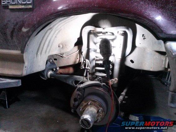 Maroon 1996 Ford Bronco front wheel well with suspension components visible
