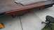 2016 Ford F-250 - Close-up of a rusty tow truck bed, showing its leaf spring suspension and metal ramps.