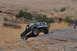 1991 Ford Bronco - A black Ford Bronco navigates a challenging rocky terrain in a desert landscape.