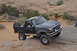 1991 Ford Bronco - This Ford Bronco is navigating a rocky trail in a desert landscape.