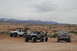 1991 Ford Bronco - A black Ford Bronco is parked in a desert landscape with two Jeeps and mountains in the background.