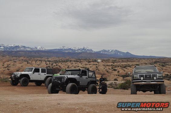 1991 Ford Bronco front view in desert with two Jeeps