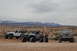 1991 Ford Bronco - A 1991 Ford Bronco is parked in a desert landscape with two Jeeps nearby under a cloudy sky.