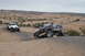 1991 Ford Bronco - Several off-road vehicles navigate a rocky, desert landscape under an overcast sky.