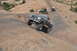 1991 Ford Bronco - Off-road vehicles navigate a challenging rocky trail in a desert landscape.