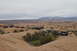 1991 Ford Bronco - A group of off-road vehicles navigates a desert trail under a cloudy sky.