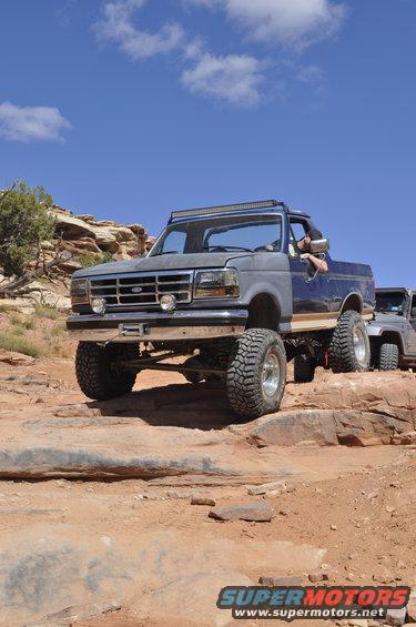 Lifted Ford Bronco off-roading on rocky terrain with another SUV behind it