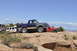 1991 Ford Bronco - A two-tone Ford Bronco is parked on a rocky trail alongside a red Jeep under a clear blue sky.
