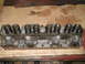 1964 Ford Galaxie - Close-up of an engine cylinder head, showing valve springs and stamped markings.