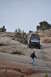 1991 Ford Bronco - A Jeep Wrangler navigates a steep, rocky terrain with onlookers observing from a higher vantage point.